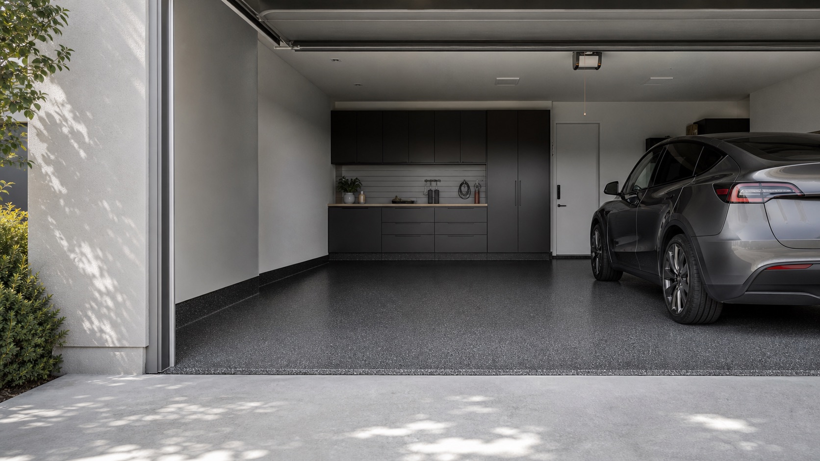 Refined residential garage with a realistic charcoal flake floor and a daily-driver vehicle